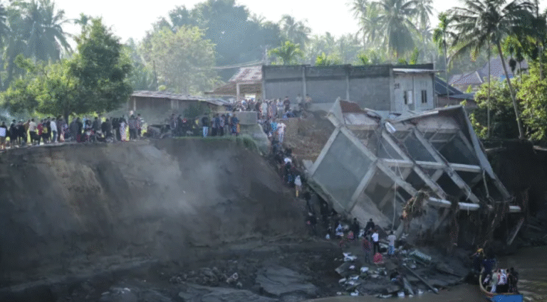 People walk down the embankment of a river to take a boat ride across, after a bridge nearby collapsed during a flood in Bireun, Aceh province, Indonesia on November 29, 2025 (PC: AP)